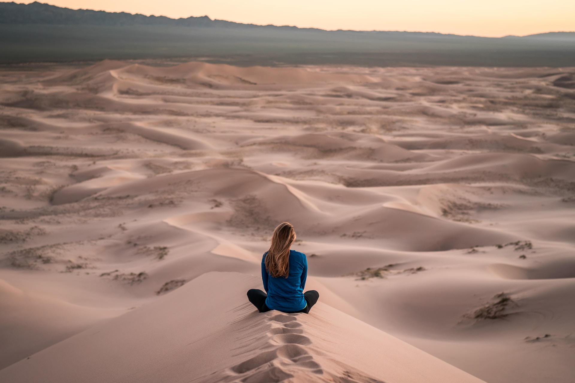 Person on sand dune enjoying quiet time